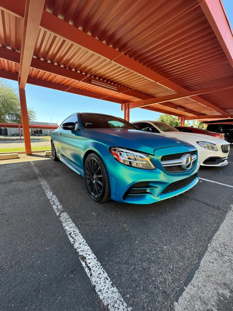 Teal Mercedes coupe parked beneath an awning